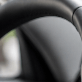 Interior de un auto moderno con una pantalla táctil de infoentretenimiento, mientras un conductor interactúa con el sistema multimedia desde el asiento del conductor.