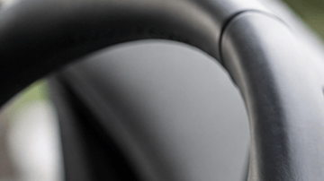 Interior de un auto moderno con una pantalla táctil de infoentretenimiento, mientras un conductor interactúa con el sistema multimedia desde el asiento del conductor.