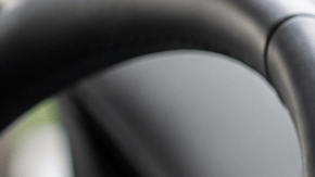 Interior de un auto moderno con una pantalla táctil de infoentretenimiento, mientras un conductor interactúa con el sistema multimedia desde el asiento del conductor.