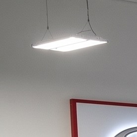 Un taller de servicio autorizado de Toyota con múltiples elevadores hidráulicos que sostienen camionetas y SUVs blancas, negras y rojas para mantenimiento y reparación.