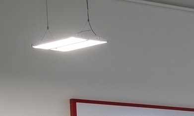 Un taller de servicio autorizado de Toyota con múltiples elevadores hidráulicos que sostienen camionetas y SUVs blancas, negras y rojas para mantenimiento y reparación.