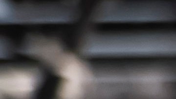 Airbag de pasajero inflado de Acura TLX 2021 en planta de ensamblaje junto a sedán gris.