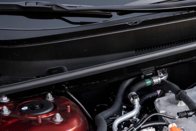 Motor híbrido del Toyota C-HR 2026 con batería de alto voltaje y cableado eléctrico naranja bajo el capó.