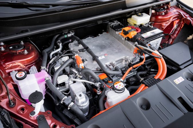 Motor híbrido del Toyota C-HR 2026 con batería de alto voltaje y cableado eléctrico naranja bajo el capó.