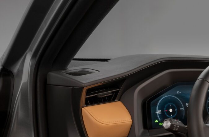 Interior Lexus NX con volante, pantalla táctil y asientos beige de cuero.