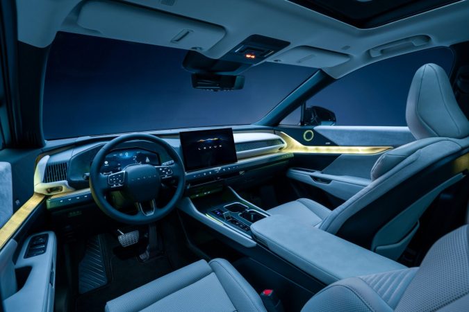 Interior Lexus TZ 2027 con pantalla central, volante digital, asientos claros e iluminación ambiental.