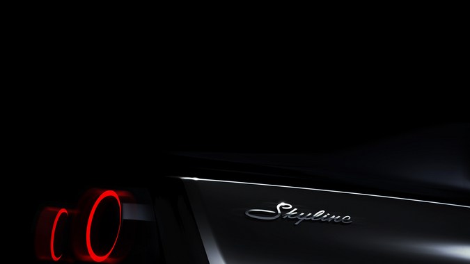 Silueta lateral en penumbra del concept car Nissan Skyline con luces traseras circulares iluminadas y logotipo cromado.