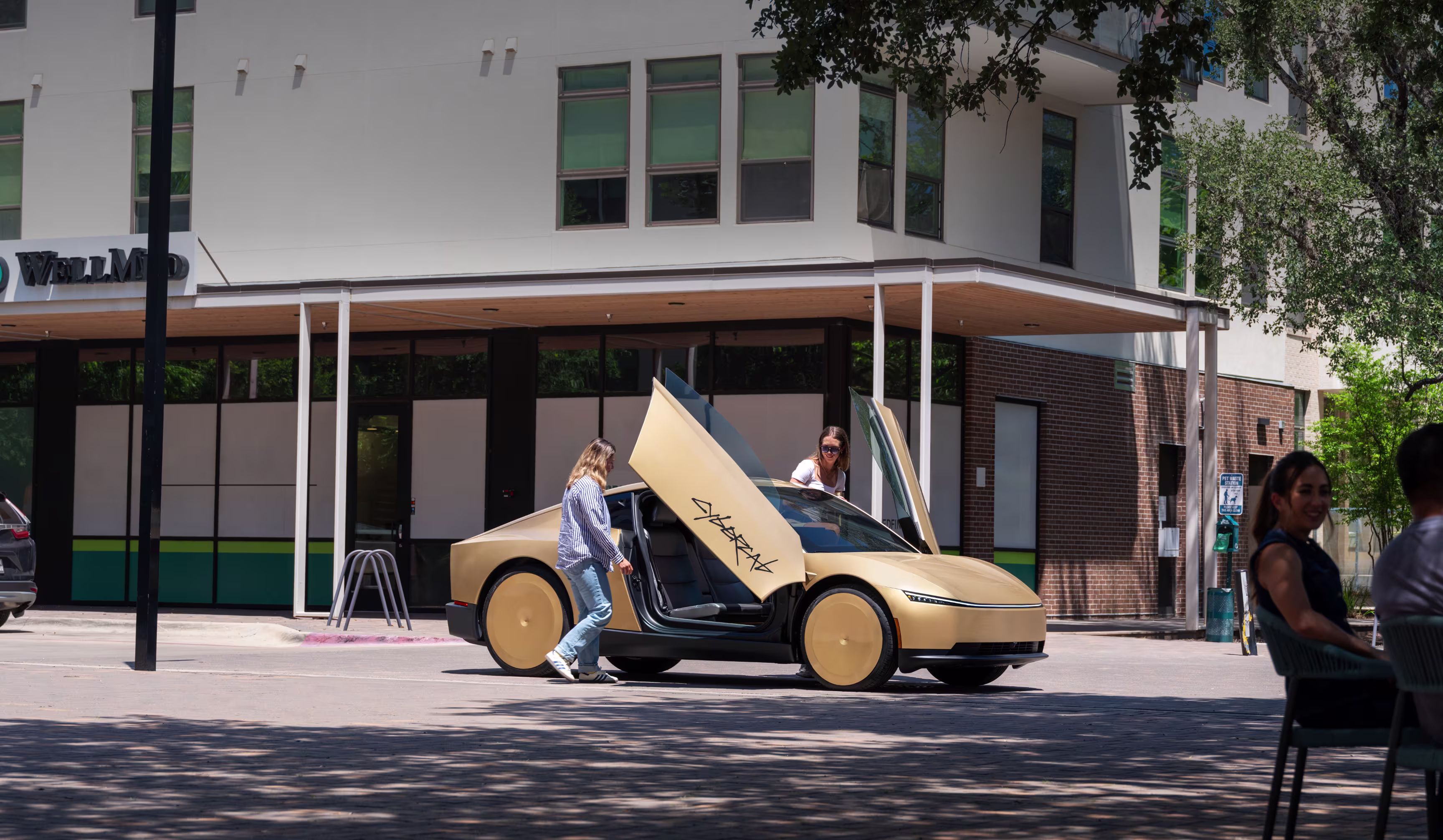 Tesla Cybercab dorado con puertas abiertas frente a un edificio urbano durante el día.
