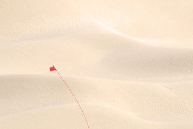 Vehículo militar GM Defense beige en pruebas en dunas del desierto de Emiratos Árabes Unidos.