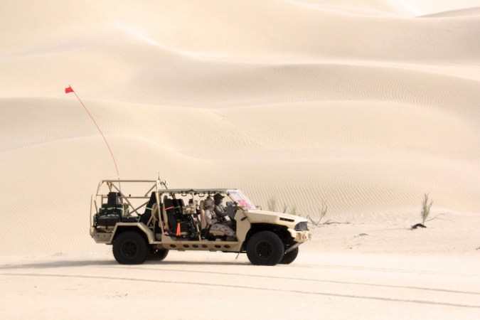 Vehículo militar GM Defense beige en pruebas en dunas del desierto de Emiratos Árabes Unidos.