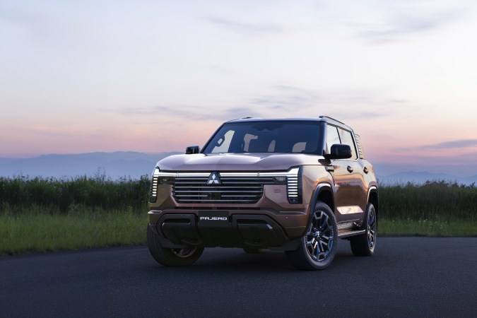 Mitsubishi Pajero 2027 color cobre estacionado frente a un paisaje montañoso durante el atardecer.