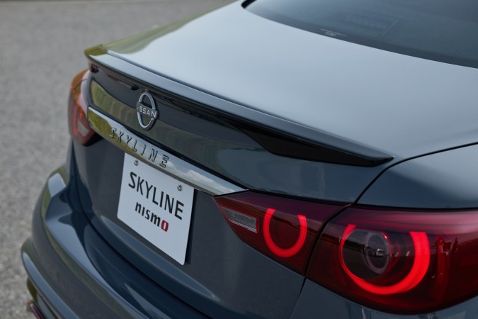 Parte trasera del Nissan Skyline NISMO destacando el alerón deportivo, emblema y las icónicas luces LED redondas.