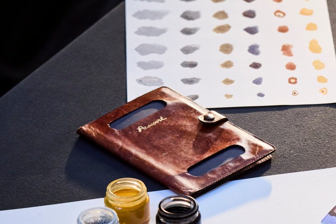 Mesa de diseño McLaren con telas, pinturas, muestras de color y foto histórica de piloto.