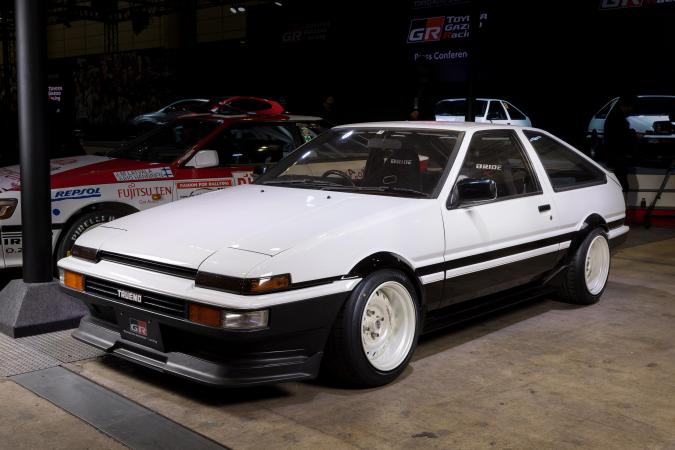 Toyota Trueno AE86 blanco modificado en exhibición de autos clásicos.