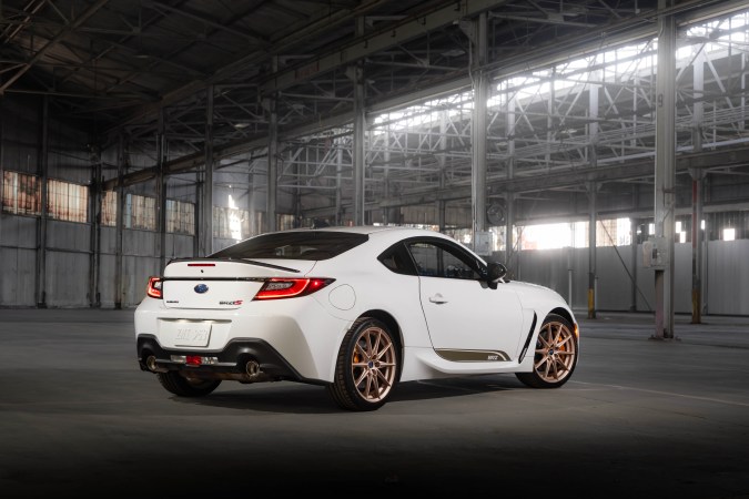 Subaru BRZ tS blanco visto desde atrás en un almacén, spoiler, luces LED y escape dual.