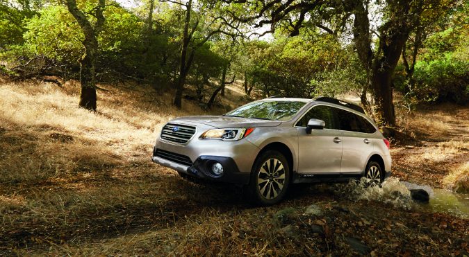 Subaru Outback 2014 plateado en terreno seco y boscoso, listo para aventura.