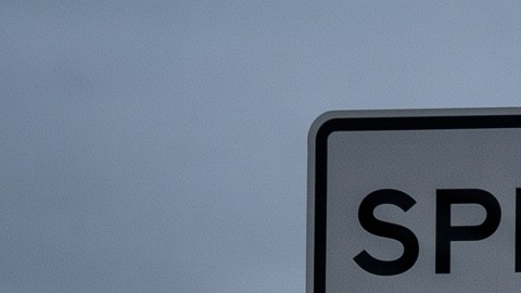 Señal de límite de velocidad 80 mph junto a choque en carretera con policía y ambulancia.