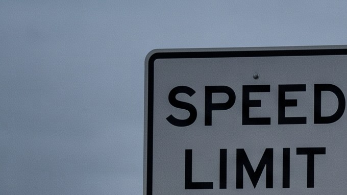 Señal de límite de velocidad 80 mph junto a choque en carretera con policía y ambulancia.