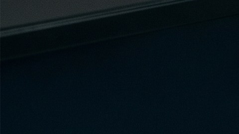 Delincuente informático administra una página web falsa de venta de autos mientras revisa código y mensajes en dos monitores.