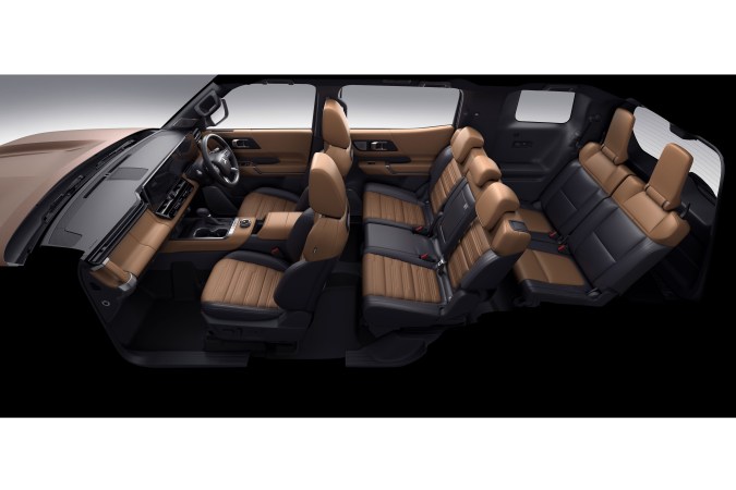 Interior del Mitsubishi Pajero 2027 con tres filas de asientos, tapicería de cuero marrón y amplio espacio para pasajeros.