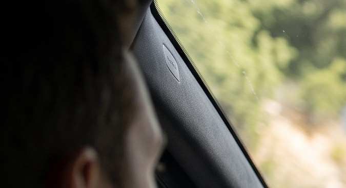Conductor y pasajera utilizan Google Podcasts en Android Auto durante un viaje por carretera.