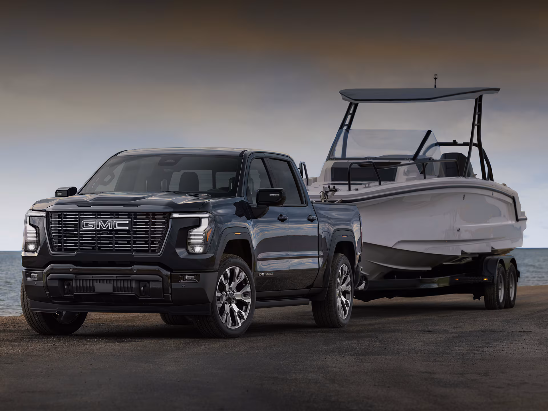 Pickup GMC Sierra Denali de lujo remolcando una lancha en la costa, demostrando su alta capacidad de arrastre.