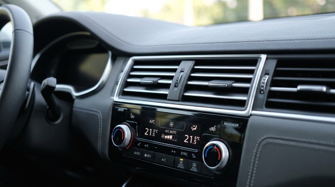 Panel de climatización de un automóvil moderno con aire acondicionado automático y temperatura independiente.