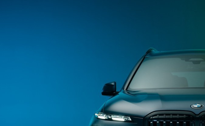 Frente de un SUV BMW ALPINA XB7 con parrilla de riñones y faros encendidos en penumbra