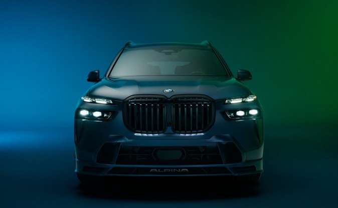 Frente de un SUV BMW ALPINA XB7 con parrilla de riñones y faros encendidos en penumbra