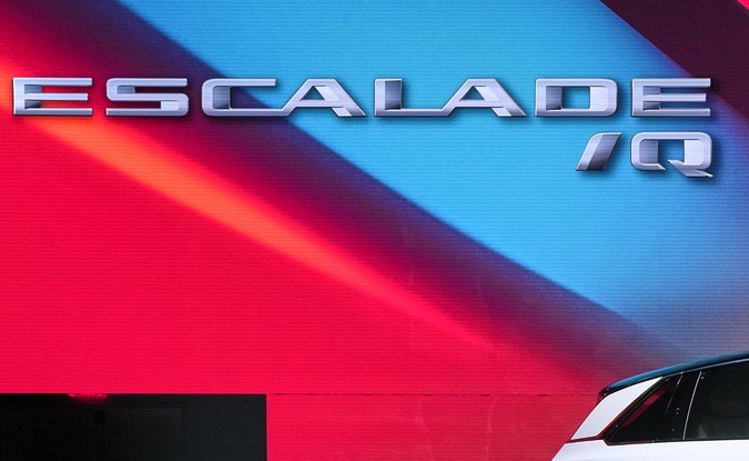 Cadillac Escalade IQ blanco con faros verticales visto de lado en un escenario de presentación