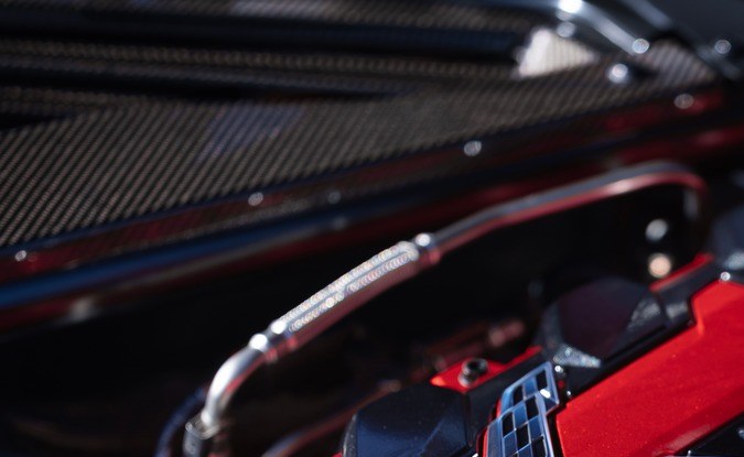 Vista frontal del motor V8 LS6 de 6.7 litros con cubierta roja instalado en el compartimento central de un Corvette 2027
