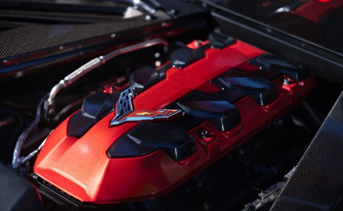 Vista frontal del motor V8 LS6 de 6.7 litros con cubierta roja instalado en el compartimento central de un Corvette 2027