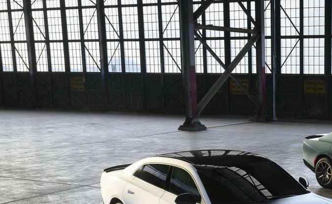 Dos Dodge Charger Scat Pack blanco y gris en hangar