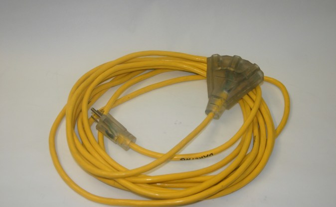 Extensión eléctrica amarilla enrollada con clavija de tres patas y un extremo con tres tomacorrientes