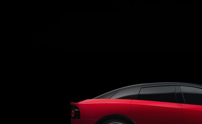 Perfil del Ferrari Luce rojo de techo negro con luces encendidas, sobre fondo oscuro.