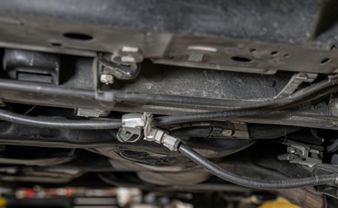 Cable del freno de estacionamiento bajo el auto en taller