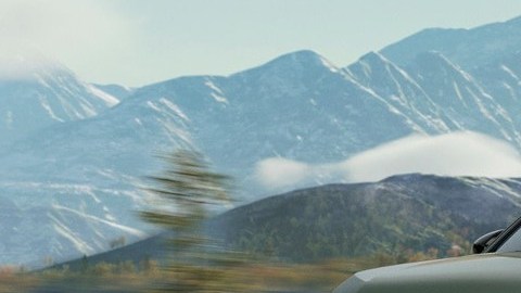 Honda CR-V TrailSport verde circulando por una carretera con montañas nevadas al fondo.