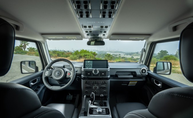 Interior del Ineos Grenadier con volante, tablero y consola de mandos en el techo