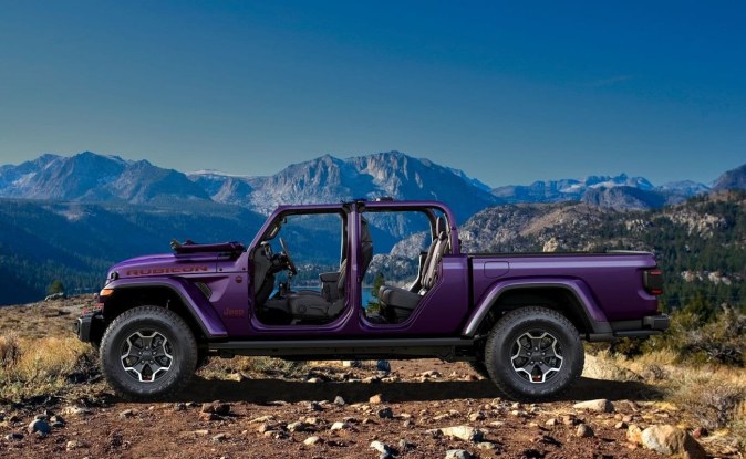 Jeep Gladiator morada vista de perfil con las puertas abiertas, con montañas al fondo.