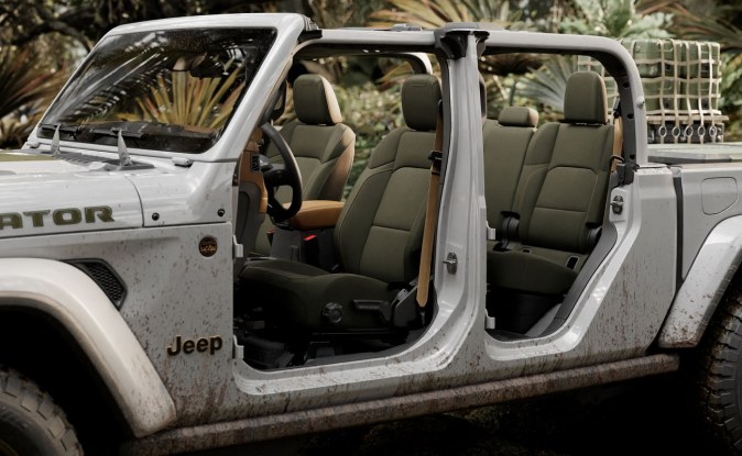 Jeep Gladiator blanca con las puertas retiradas, mostrando los asientos delanteros y traseros en un entorno de selva.
