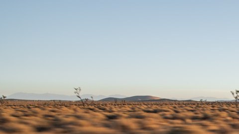 Kia EV6 gris circulando por una carretera del desierto, vista de frente y de lado.
