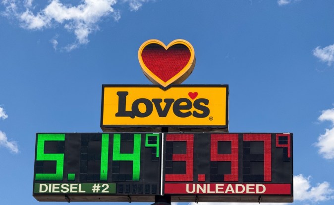 Letrero de una parada de camiones con el precio del diésel en 5.14 dólares y la gasolina regular en 3.97 dólares por galón, bajo un cielo azul