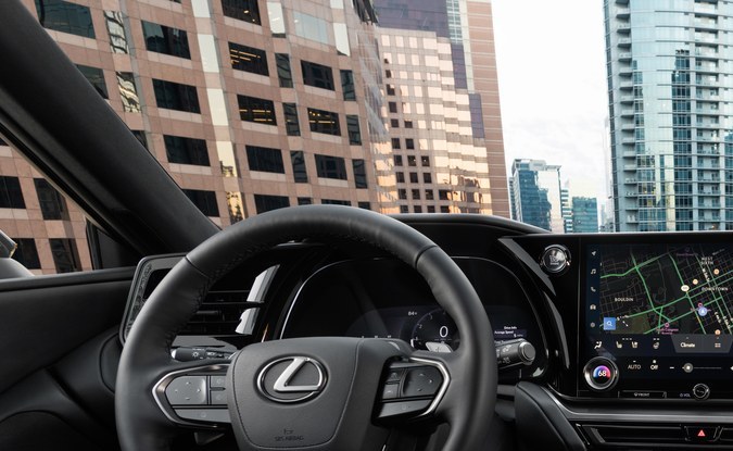 Tablero de un SUV Lexus con volante, pantalla central táctil grande y asientos de piel negros.