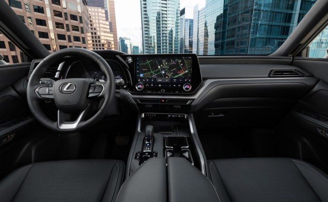 Tablero de un SUV Lexus con volante, pantalla central táctil grande y asientos de piel negros.