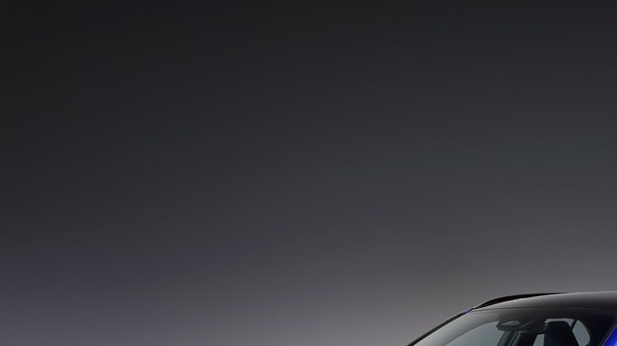 Lexus UX 300h F Sport azul visto de frente en ángulo, en un estudio de fondo gris oscuro.