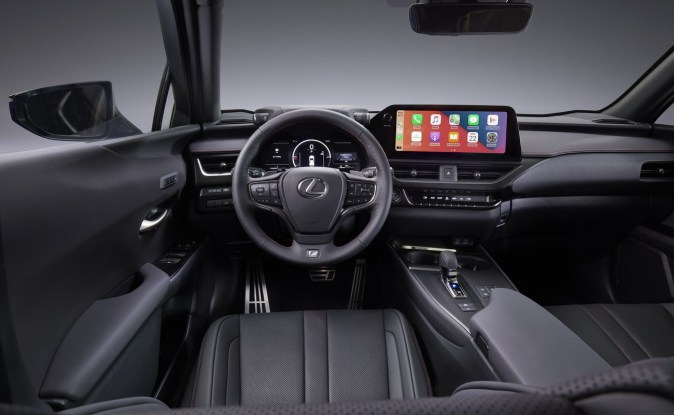 Interior negro del Lexus UX 300h con volante, pantalla central táctil y asientos deportivos de piel.