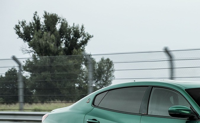 Maserati Quattroporte Trofeo verde metálico circulando a alta velocidad en un circuito