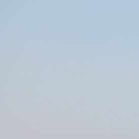 Mazda CX-5 roja vista de frente y de lado, estacionada sobre la arena de una playa.