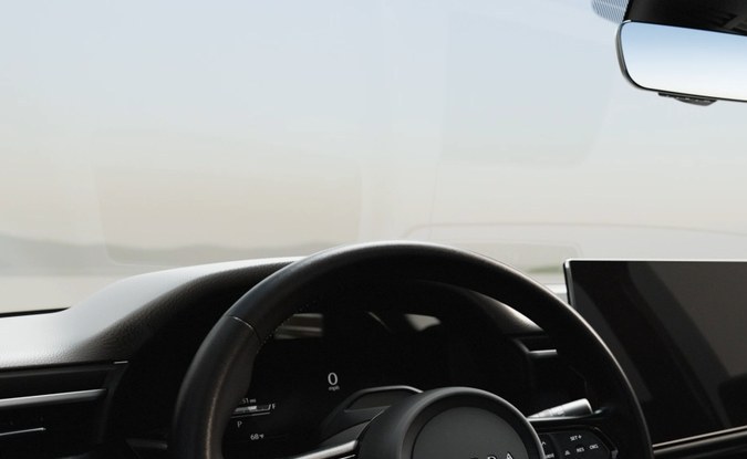 Tablero de la Mazda CX-5 en tonos oscuros, con volante y pantalla central sobre la consola.