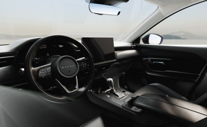 Tablero de la Mazda CX-5 en tonos oscuros, con volante y pantalla central sobre la consola.